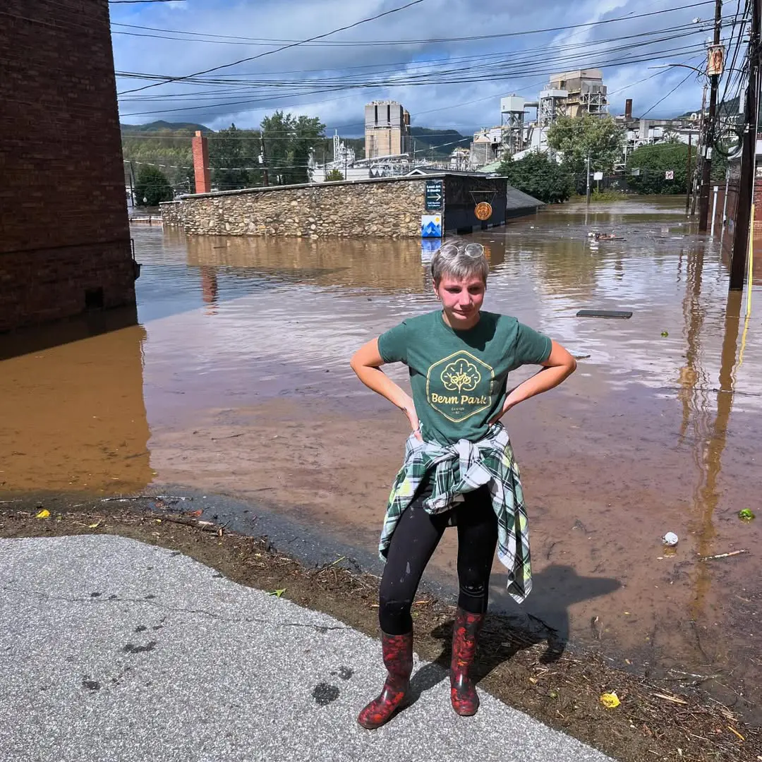 Hannah Burnisky standing in flood water outside Cold Mountain Art Collective