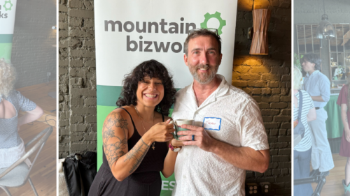 Guests mingle at a Mountain BizWorks networking event, including Trevor Baker holding the Jane Renfroe Award mug near a Mountain BizWorks banner.